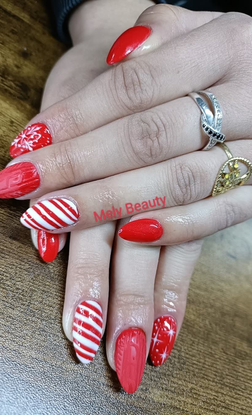 Manucure festive rouge avec rayures et motifs blancs